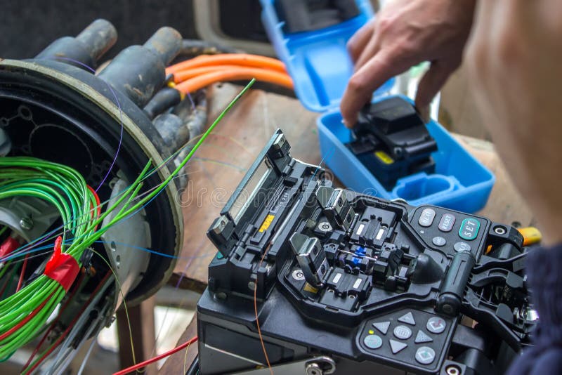 Technician working with fiber optic cables and termination equipment.
