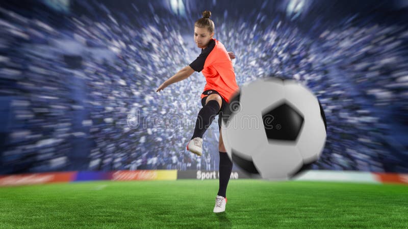 Futbolista femenino en el uniforme de la naranja que golpea la bola con el pie imagen de archivo Futbolista femenino en el uniforme de la naranja que golpea la bola con el pie imagen de archivo