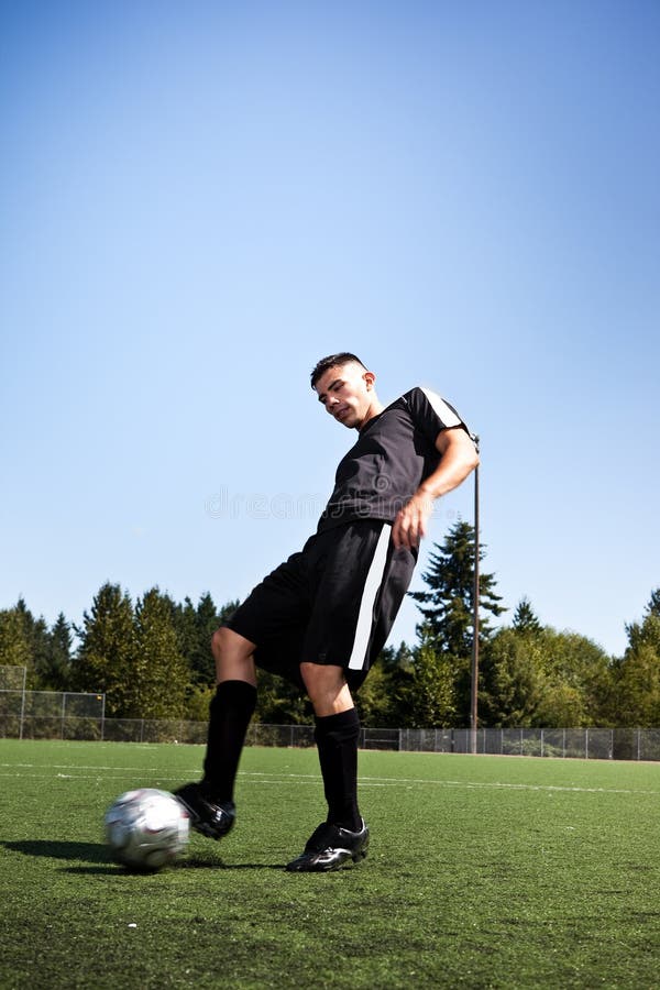 Futbolista hispánico del fútbol o que golpea una bola con el pie fotos de archivo libres de regalías Futbolista hispánico del fútbol o que golpea una bola con el pie fotos de archivo libres de regalías