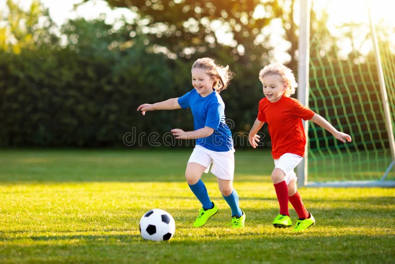 Futebol do jogo das crianças Criança no campo de futebol