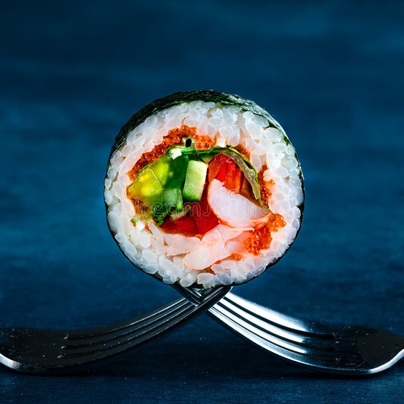 παραδοσιακό ιαπωνικό futomaki roll γεμισμένο με tobiko caviar καβούρι και ντομάτα futomaki shimoda maki κοντά σε ένα πιρούνι