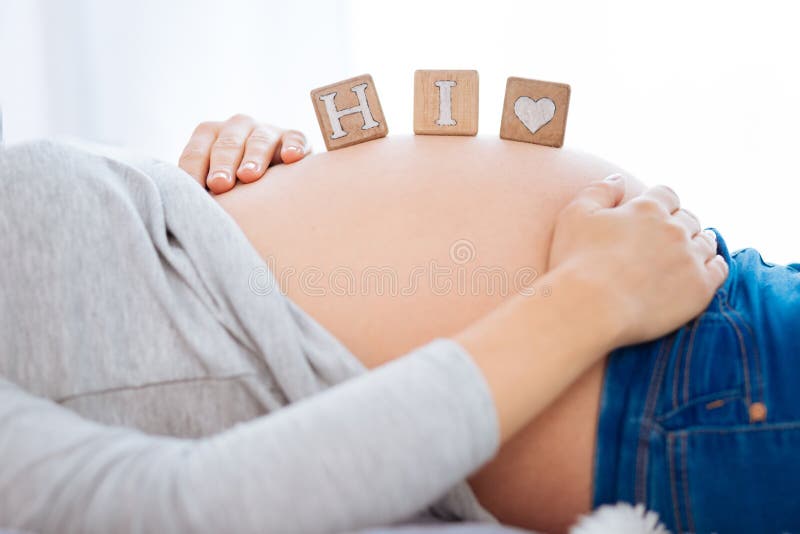 Wooden Cubes Located On The Pregnant Woman Tummy Stock