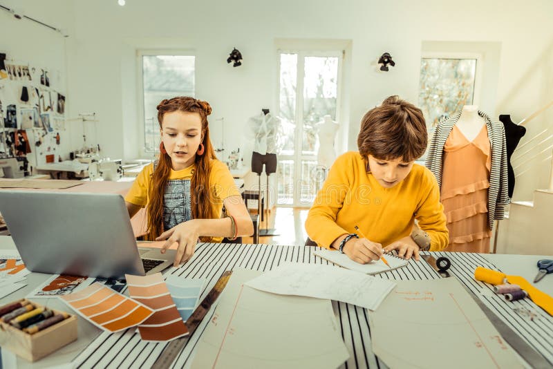 Future fashion designers working in the atelier of their mother royalty free stock image Future fashion designers working in the atelier of their mother royalty free stock image