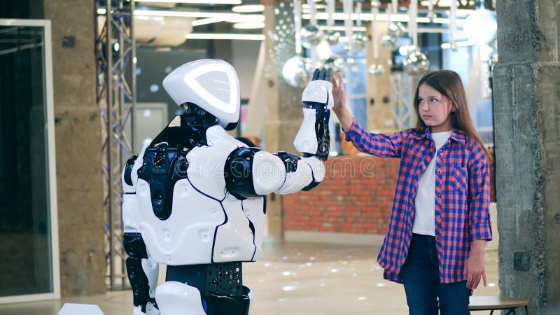 Futurista androide che tocca le mani con una bambina. concetto di intelligenza artificiale. archivi video