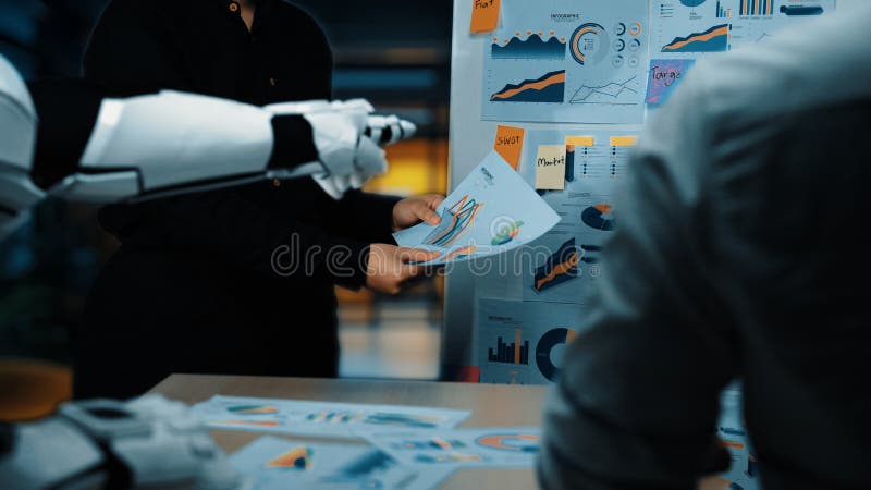 A modern office setting highlights a robotic arm assisting in a business meeting by presenting data visualizations to a professional team, emphasizing innovation and collaboration. Noogenesis. Robots working futuristic office stock images, royalty-free photos and pictures