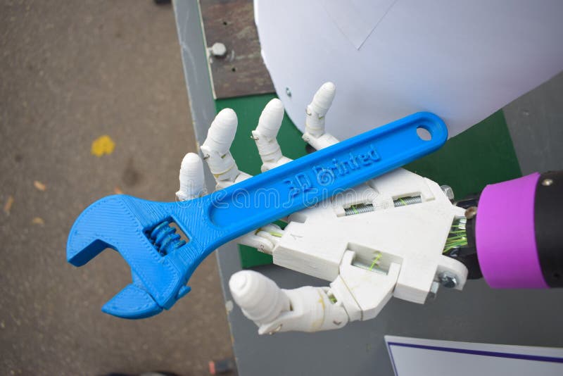 Futuristic man hand, white robot arm printed on a 3d printer. Cyborg hand with wrench close up. 3D printing, three-dimensional object. Futuristic man hand, white robot arm printed on a 3d printer. Cyborg hand with wrench close up. 3D printing, three-dimensional object