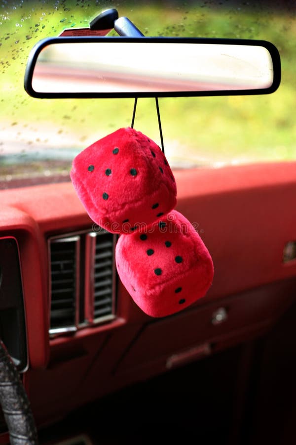 Fuzzy dice hang from the rear-view mirror of a vintage 'low rider