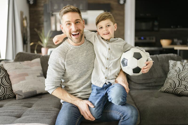 Fußball-Fans emotionaler Vater und Sohn jubeln mit Fußball spielen Sport im Fernsehen zu Hause stockbild