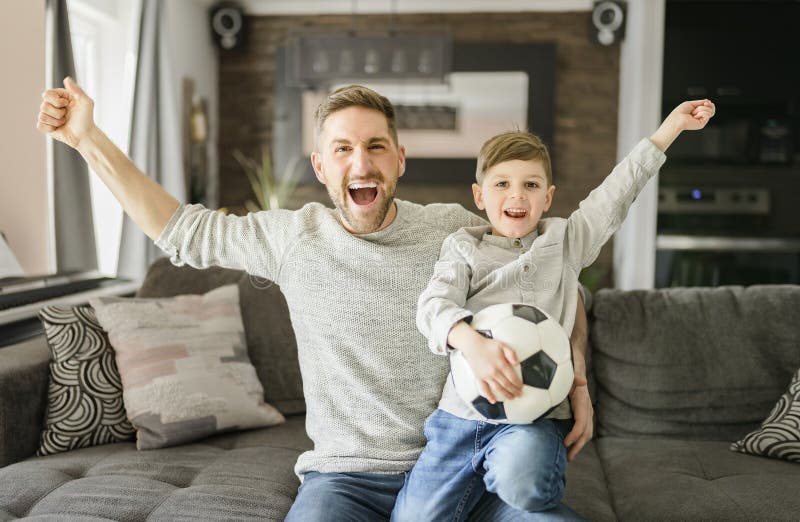 Fußball-Fans emotionaler Vater und Sohn jubeln mit Fußball spielen Sport im Fernsehen zu Hause lizenzfreies stockfoto