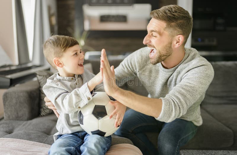 Fußball-Fans emotionaler Vater und Sohn jubeln mit Fußball spielen Sport im Fernsehen zu Hause stockfotografie