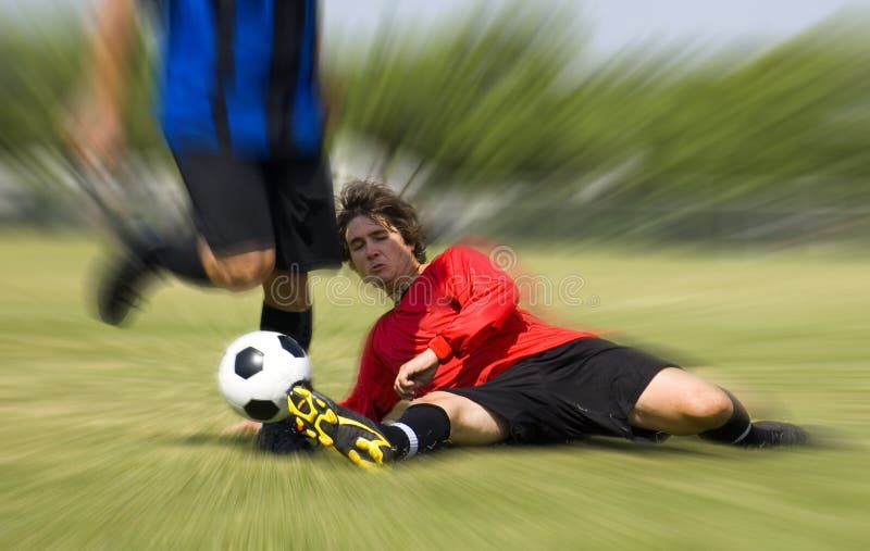 Football - Soccer player making sliding tackle. Football - Soccer player making sliding tackle