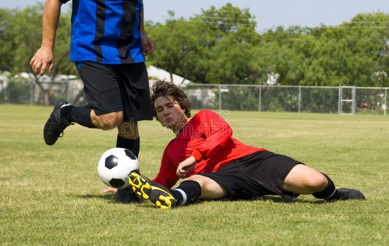 Football - Soccer player making sliding tackle. Football - Soccer player making sliding tackle