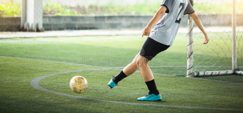 Fußballer laufen zu kicken mit verschwommenem Ball auf grünen Kunstrasen. lizenzfreies stockfoto
