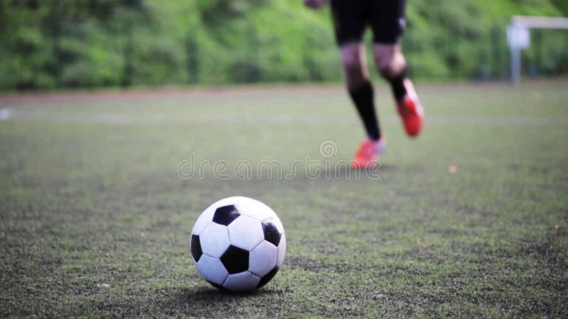 Fußballspieler, der mit Ball auf Feld spielt