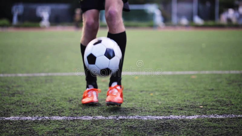 Fußballspieler, der mit Ball auf Feld spielt