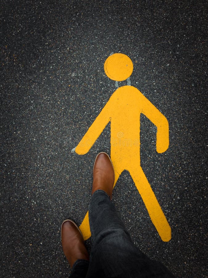 Fußgängerzeichen auf Pflasterung mit Füßen