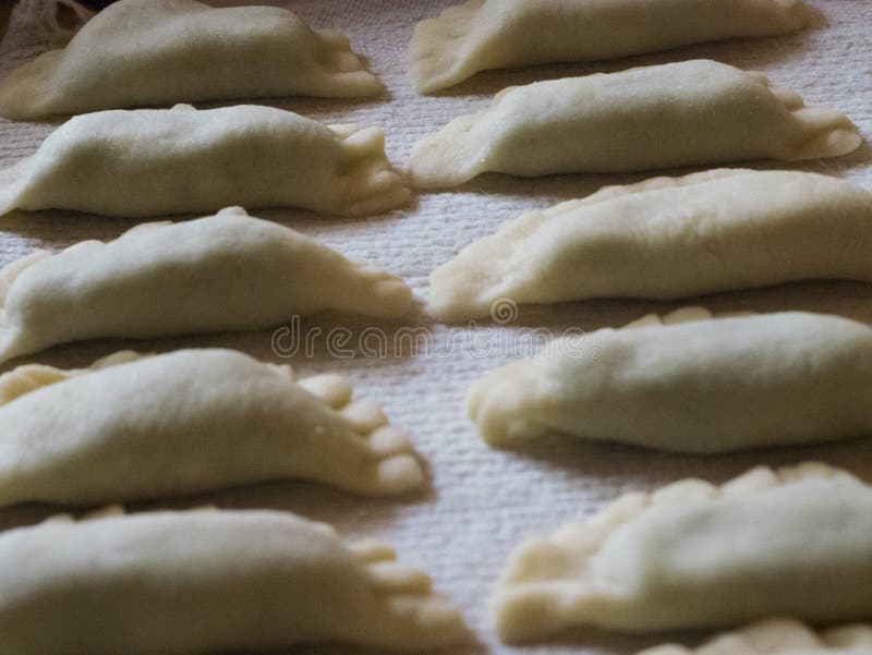 Fylld yttersida av raviolit med handgjort klart för spenat och för ricotta att lagas mat i koka vatten, typisk södra Tyrolean royaltyfri bild Fylld yttersida av raviolit med handgjort klart för spenat och för ricotta att lagas mat i koka vatten, typisk södra Tyrolean royaltyfri bild