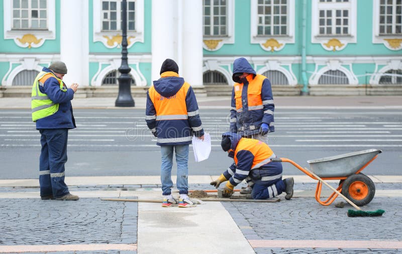 Four workers repair paving stones in the city square, Palace Square, St. Petersburg, Russia, April 22, 2024. Four workers repair paving stones in the city square, Palace Square, St. Petersburg, Russia, April 22, 2024