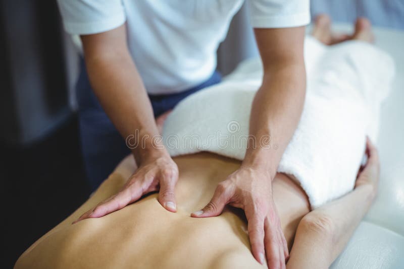 Fysioterapeut som tillbaka ger massage till en kvinna fotografering för bildbyråer Fysioterapeut som tillbaka ger massage till en kvinna fotografering för bildbyråer