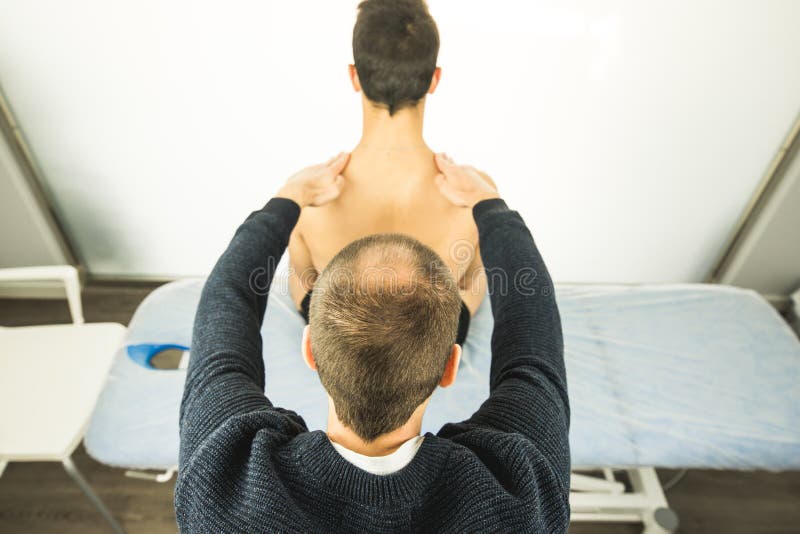 Fysiotherapeut die een jonge mensenrug onderzoeken Fysiotherapieconcept royalty-vrije stock afbeeldingen Fysiotherapeut die een jonge mensenrug onderzoeken Fysiotherapieconcept royalty-vrije stock afbeeldingen