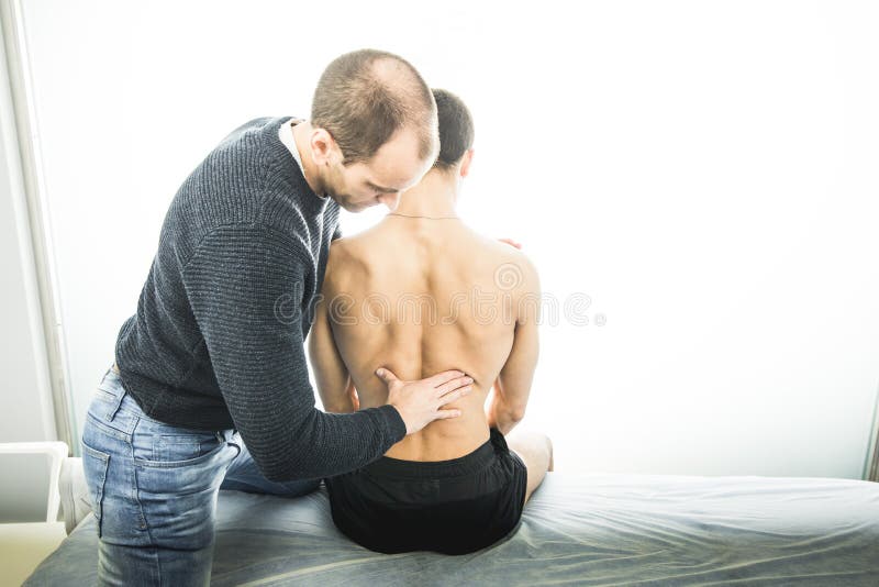 Fysiotherapeut die een jonge mensenrug onderzoeken Fysiotherapieconcept royalty-vrije stock foto Fysiotherapeut die een jonge mensenrug onderzoeken Fysiotherapieconcept royalty-vrije stock foto