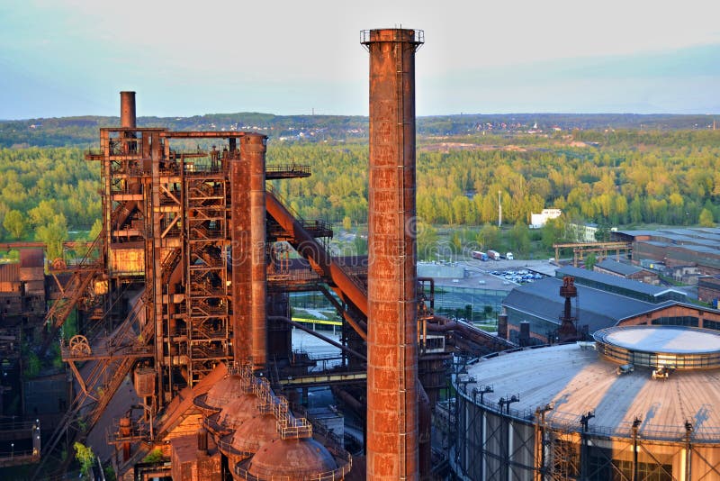 Fábrica abandonada das indústrias siderúrgicas - chaminé oxidada ensolarado pelo sol Fábrica abandonada das indústrias siderúrgicas - chaminé oxidada ensolarado pelo sol