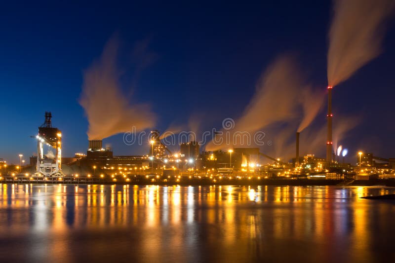 Fábrica de aço holandesa com os smokestacks na noite fotografia de stock Fábrica de aço holandesa com os smokestacks na noite fotografia de stock