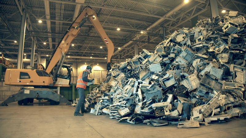 Fábrica de reciclaje de basura electrónica. inspector de vertederos está examinando una pila de basura