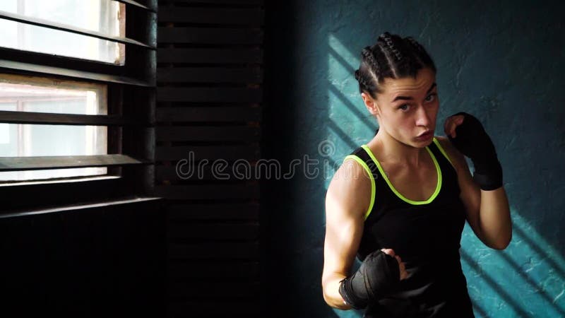 Färdig härlig ung boxningkvinnautbildning som stansar i konditionstudioultrarapid