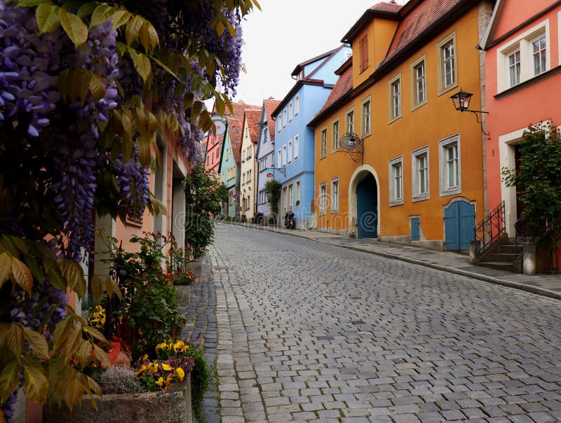 Färgrik gata med vårblommor i Rothenburg obder Tauber, Tyskland royaltyfri foto Färgrik gata med vårblommor i Rothenburg obder Tauber, Tyskland royaltyfri foto