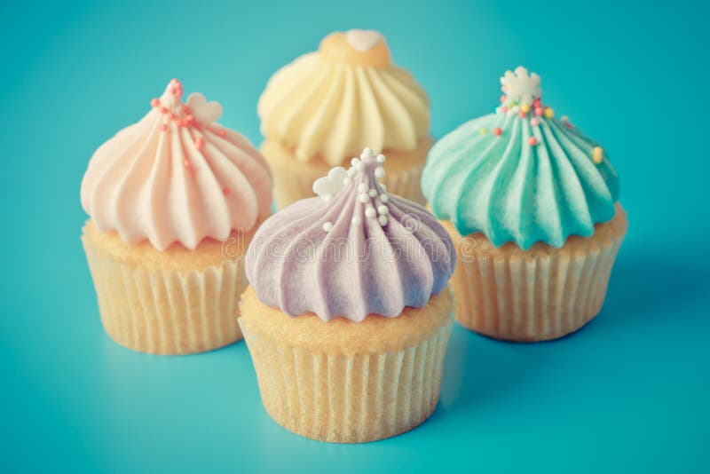 Färgrik muffin fyra på blå bakgrund i pastellfärgad signal för tappning royaltyfri fotografi