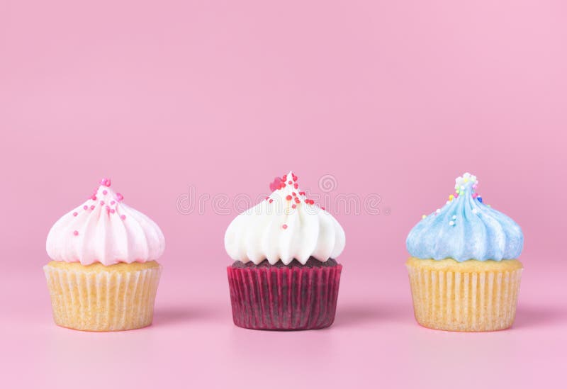 Färgrik muffin tre på rosa bakgrund arkivfoto
