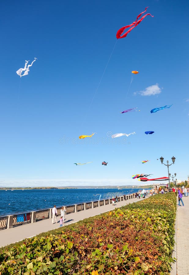 Färgrika drakar som flyger mot en blå himmel på stadsinvallningen fotografering för bildbyråer Färgrika drakar som flyger mot en blå himmel på stadsinvallningen fotografering för bildbyråer