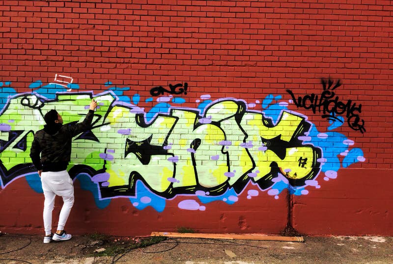 Färgrika grafitti för gatakonstnärmålning på den röda väggen royaltyfri fotografi Färgrika grafitti för gatakonstnärmålning på den röda väggen royaltyfri fotografi