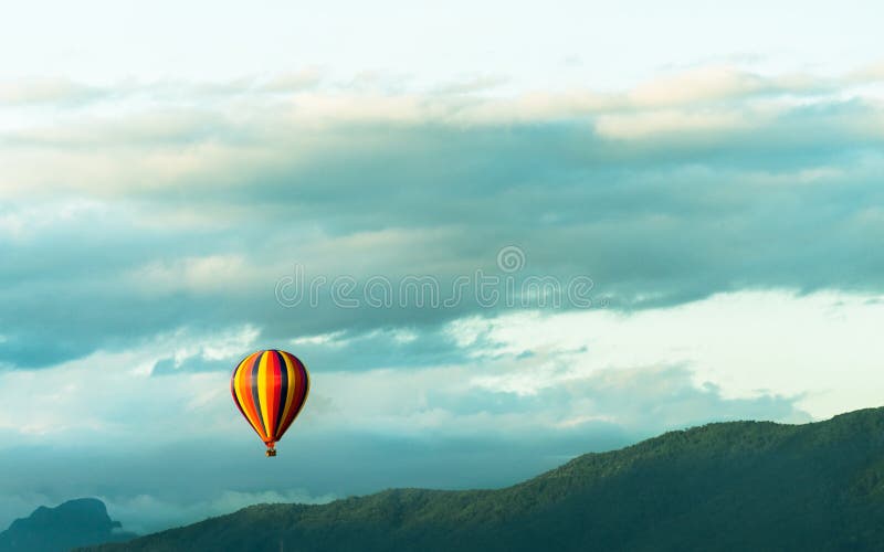 Färgrika hot-air ballonger som flyger över berg fotografering för bildbyråer Färgrika hot-air ballonger som flyger över berg fotografering för bildbyråer