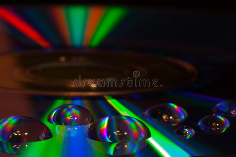 Färgrika vattendroppar på CD-/DVDdiskett royaltyfria bilder Färgrika vattendroppar på CD-/DVDdiskett royaltyfria bilder