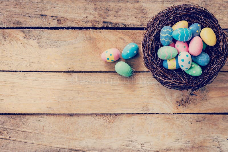 Färgrikt easter ägg i redet på wood bakgrund med utrymme royaltyfri foto Färgrikt easter ägg i redet på wood bakgrund med utrymme royaltyfri foto