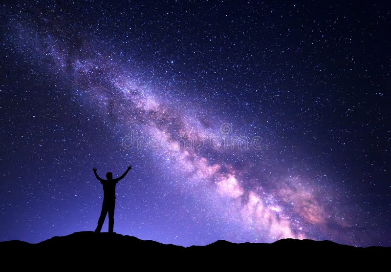 Night colorful landscape with purple Milky Way and silhouette of a standing sporty man with raised up arms on the mountain. Sky full of stars, space. Night colorful landscape with purple Milky Way and silhouette of a standing sporty man with raised up arms on the mountain. Sky full of stars, space.