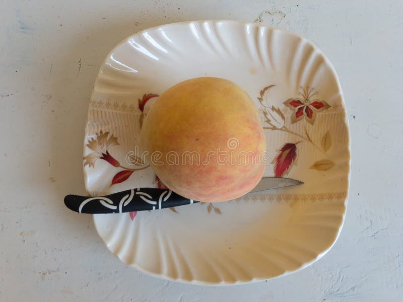 Färsk persikofrukt i plattor med kniv arkivfoton