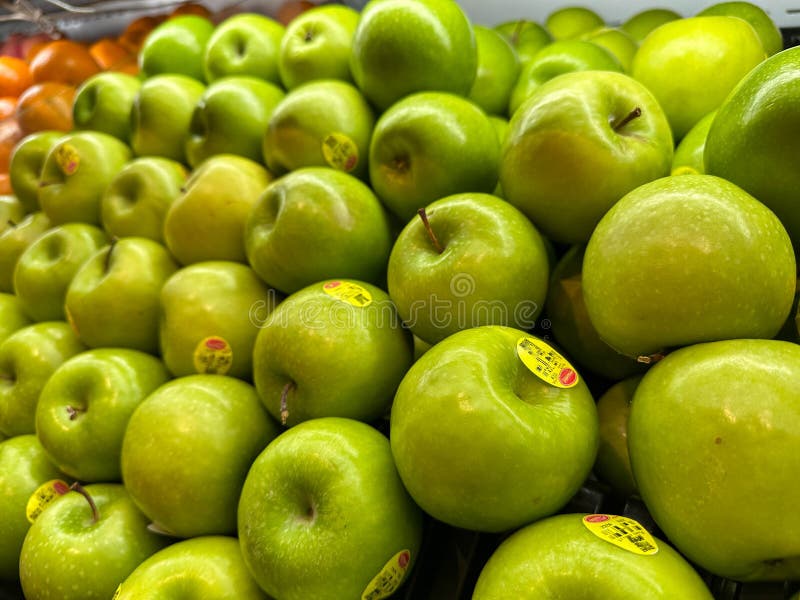 Färska gröna äpplen som visas i ett Grocery Store med ljust skinn och brant färg royaltyfria bilder