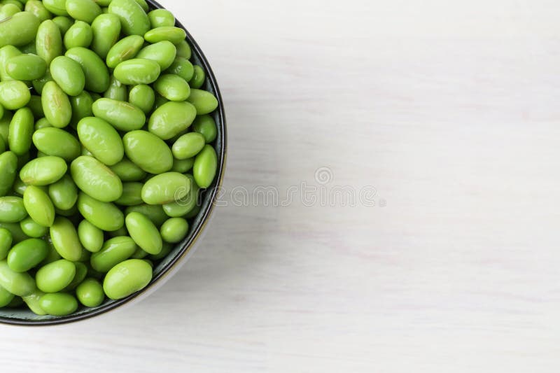Färska edamame sojabönor i skål på vitt träbord, ovanifrån. Utrymme för text royaltyfria foton