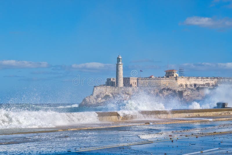 Fästningen och fyren av El Morro i havannacigarr med havet vinkar crshing på skyddsmuren mot havet arkivfoton Fästningen och fyren av El Morro i havannacigarr med havet vinkar crshing på skyddsmuren mot havet arkivfoton