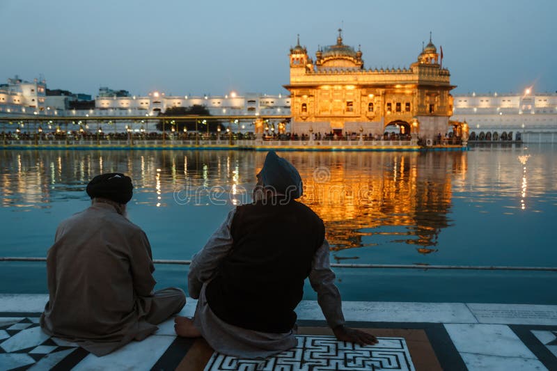 24 février 2018 Amritsar, Inde Deux Sikhs indiens équipe se repose près de l'eau du temple d'or la nuit photo libre de droits 24 février 2018 Amritsar, Inde Deux Sikhs indiens équipe se repose près de l'eau du temple d'or la nuit photo libre de droits