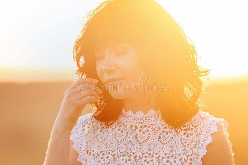 Cute happy beautiful woman female against a background of the sunset. Gold backlight. Close up. Nice emotions, face, lifestyle, outdoors, portrait, young, attractive, individual, enjoyment, happiness, individuality, real, confidence, confident, looking, people, person, smiling, casual, natural, slow, blowing, campus, enjoying, normal, carefree, freedom, human, independent, wind, positive, vacation, fresh, awe, breathing, escape, faith, feeling, hope, relaxed, windy, sunny, summer, pretty. Cute happy beautiful woman female against a background of the sunset. Gold backlight. Close up. Nice emotions, face, lifestyle, outdoors, portrait, young, attractive, individual, enjoyment, happiness, individuality, real, confidence, confident, looking, people, person, smiling, casual, natural, slow, blowing, campus, enjoying, normal, carefree, freedom, human, independent, wind, positive, vacation, fresh, awe, breathing, escape, faith, feeling, hope, relaxed, windy, sunny, summer, pretty