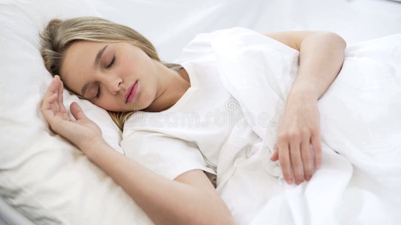 Fêmea bonita nova que dorme quietamente na cama, colchão ortopédico confortável fotografia de stock royalty free Fêmea bonita nova que dorme quietamente na cama, colchão ortopédico confortável fotografia de stock royalty free