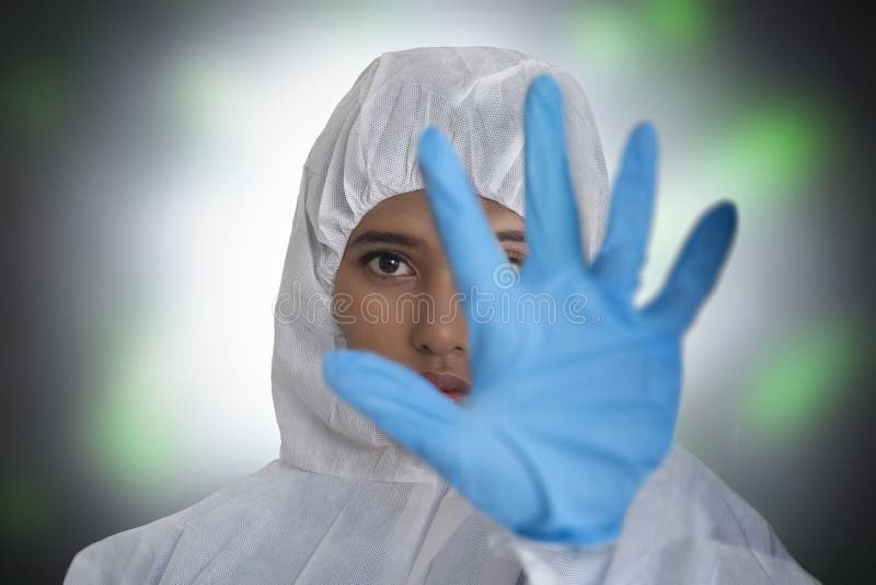 Fêmea no terno da proteção da poluição põe sua mão acima de mostrar o sinal da parada fotos de stock Fêmea no terno da proteção da poluição põe sua mão acima de mostrar o sinal da parada fotos de stock