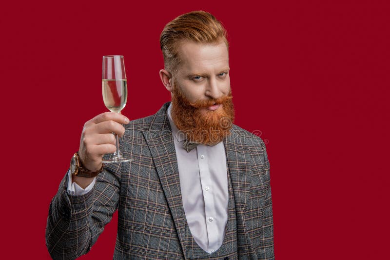 Fête avec champagne. acclamer et célébrer. élégant tuxedo homme tenir une coupe de champagne isolé sur rouge image stock