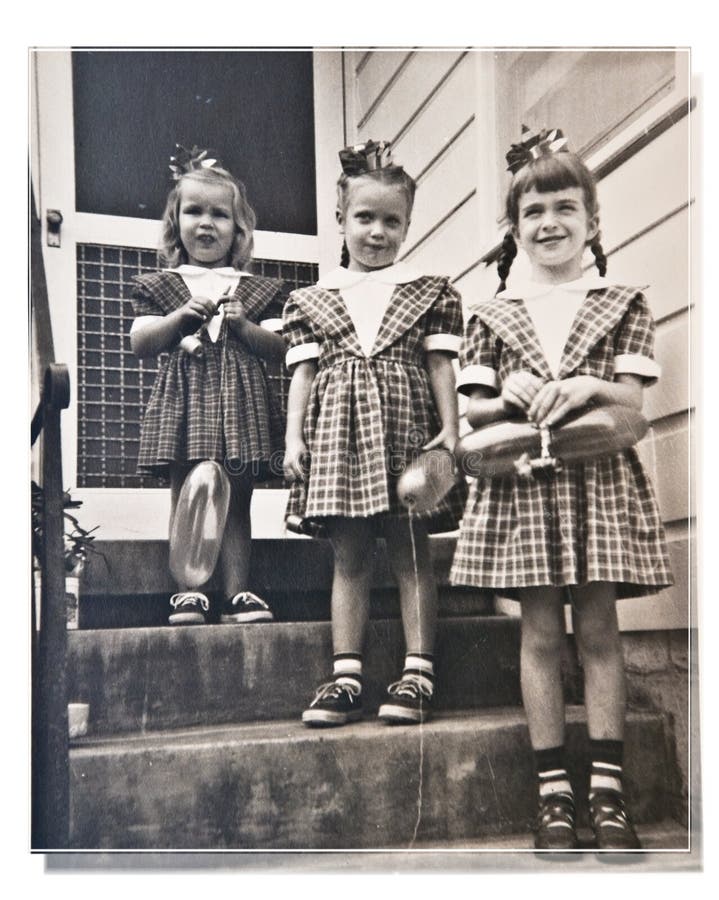 Three girls, cousins, dressed alike, at a birthday party posing for a picture on the front steps. 1950's. Three girls, cousins, dressed alike, at a birthday party posing for a picture on the front steps. 1950's
