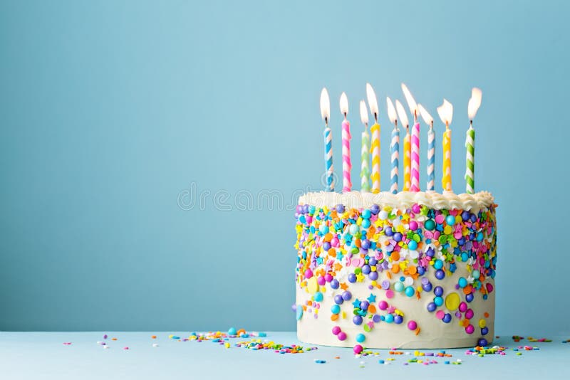 Födelsedagkaka som dekoreras med färgrika stänk och tio stearinljus