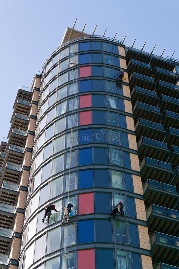 Fönsterrengöringsmedel som abseiling byggnaden arkivfoto Fönsterrengöringsmedel som abseiling byggnaden arkivfoto